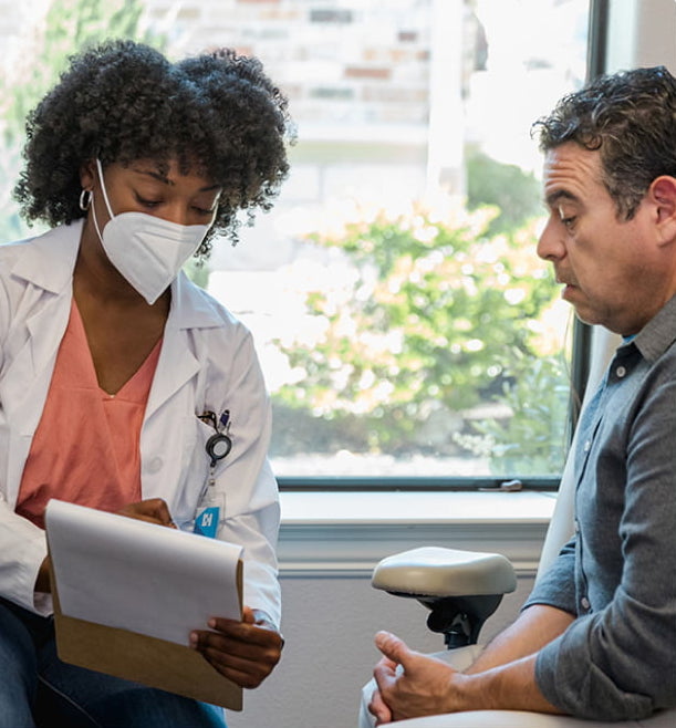 Doctor consulting with a patient seated in a chair, Atlanta, GA
