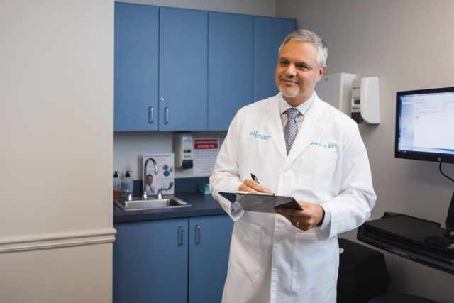A doctor with a file and pen in his hand discussing with a patient in Atlanta, GA