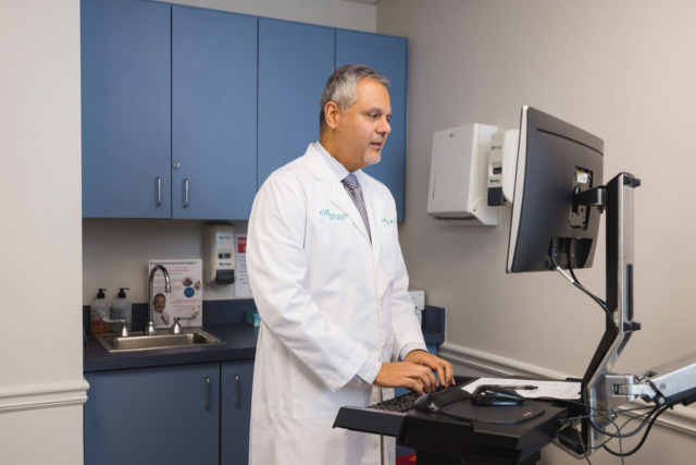 GI Specialists team member candid photo checking patient's info
