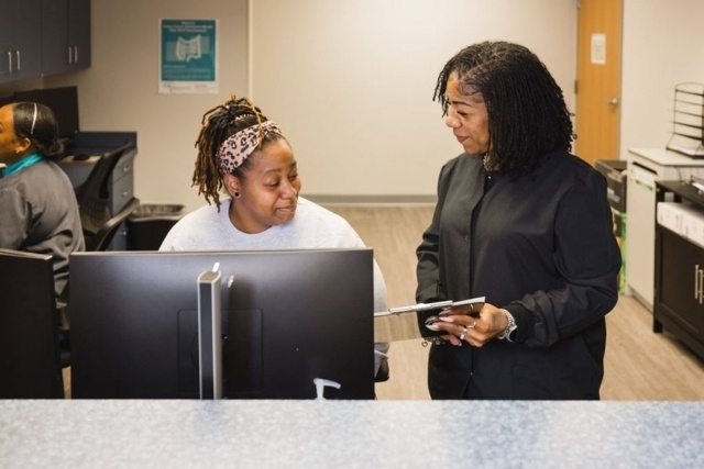 Staff members working together at a front desk in a medical office in Atlanta, GA