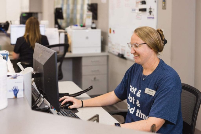 The woman is reviewing files in the hospital at GI Specialists of Georgia
