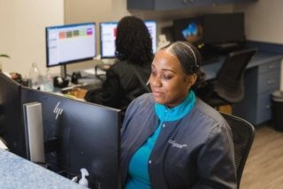 A smiling woman looking at a screen at GI Specialists of Georgia