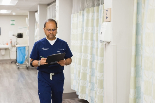 Healthcare professional in navy scrubs walking in a hospital hallway in Atlanta, GA
