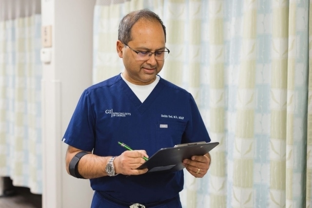Healthcare professional in navy scrubs holding a clipboard and pen in Atlanta, GA
