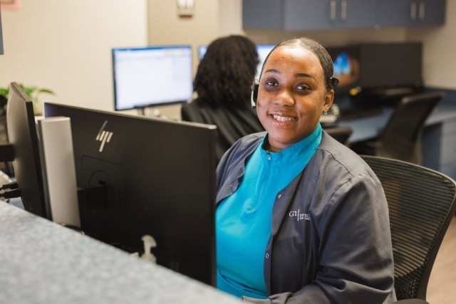 office-worker-at-computer-desk A Person Working at a Computer Desk at the GI Specialists of Georgia's Office