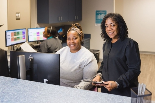 Three office staff members are working at a reception desk with computers in Atlanta, GA
