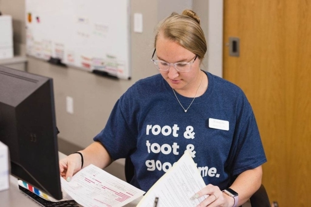 woman-reviewing-patient-forms Person Reviewing Patient Documents at a Desk in GI Specialists of Georgia's Office
