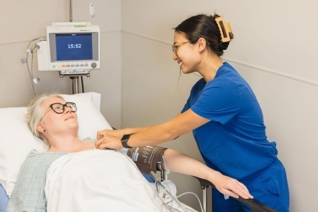 Medical professional assisting a patient during a bedside monitoring procedure in Atlanta, GA