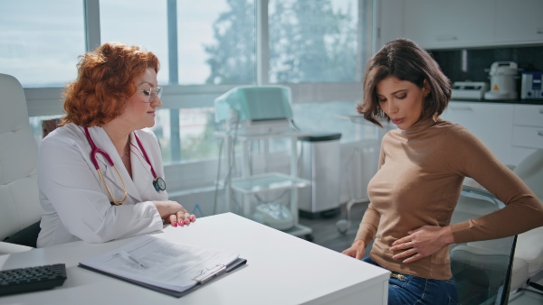 Woman explaining symptoms to GI doctor
